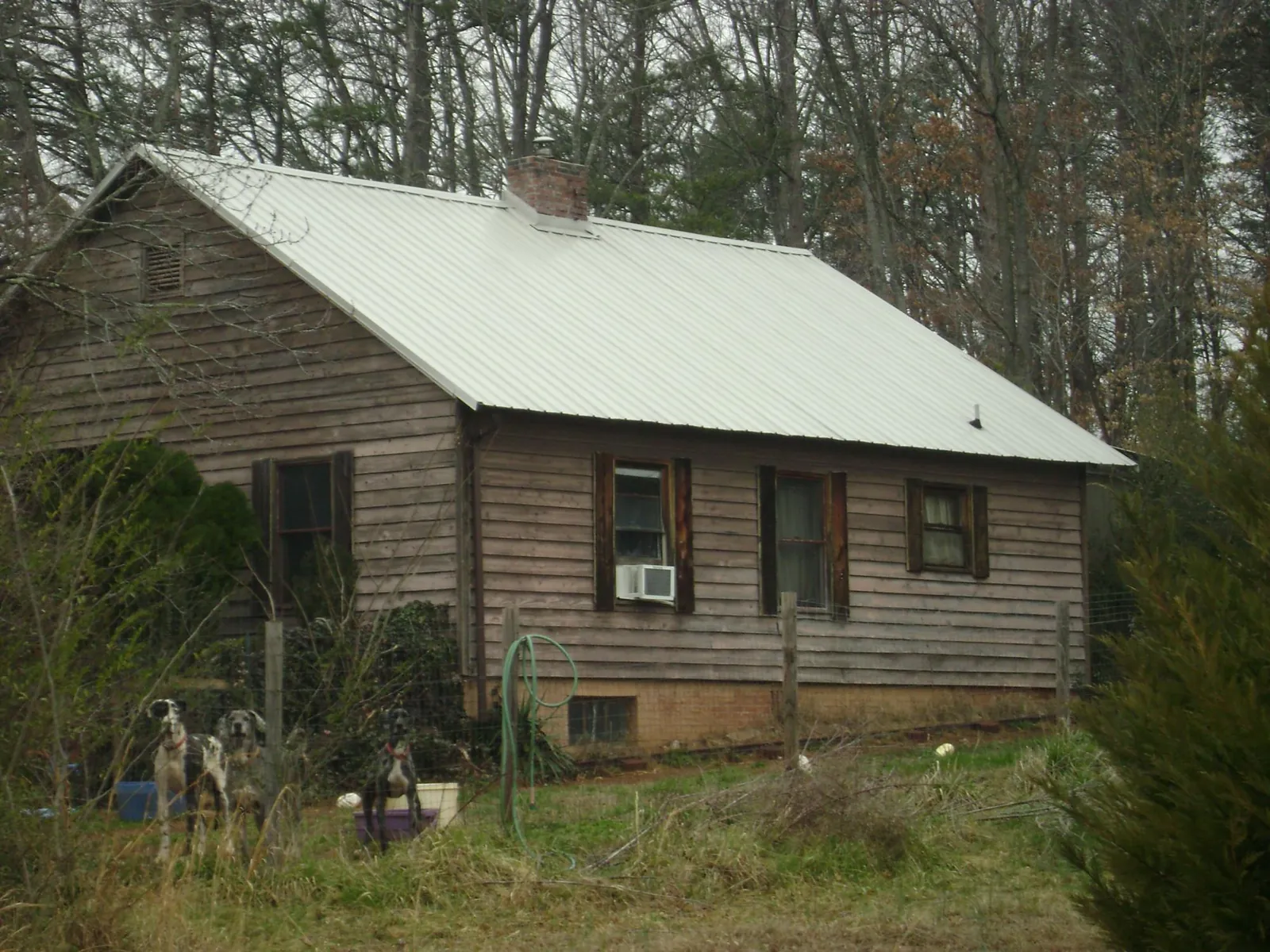 White metal roof on an old wood sided farmhouse, from a Metal Roof Installation job in Plantation